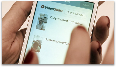 Hand holding a smart phone displaying Video Share.