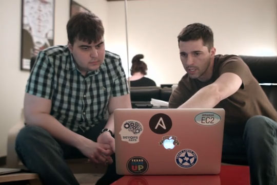 Two men looking at something on a laptop in the uStudio video solutions in office.